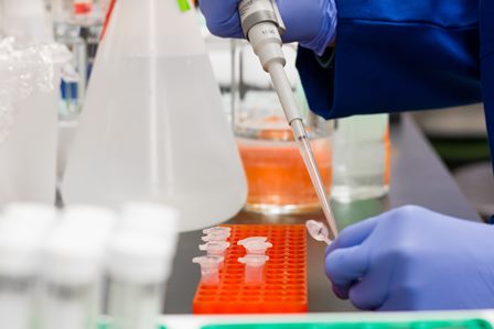 Tecnico di laboratorio con pipetta in mano